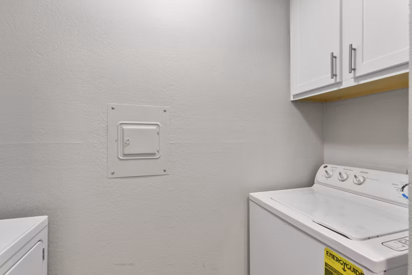 Laundry room with modern appliances in Creekwood Apartments offering convenience and style for residents