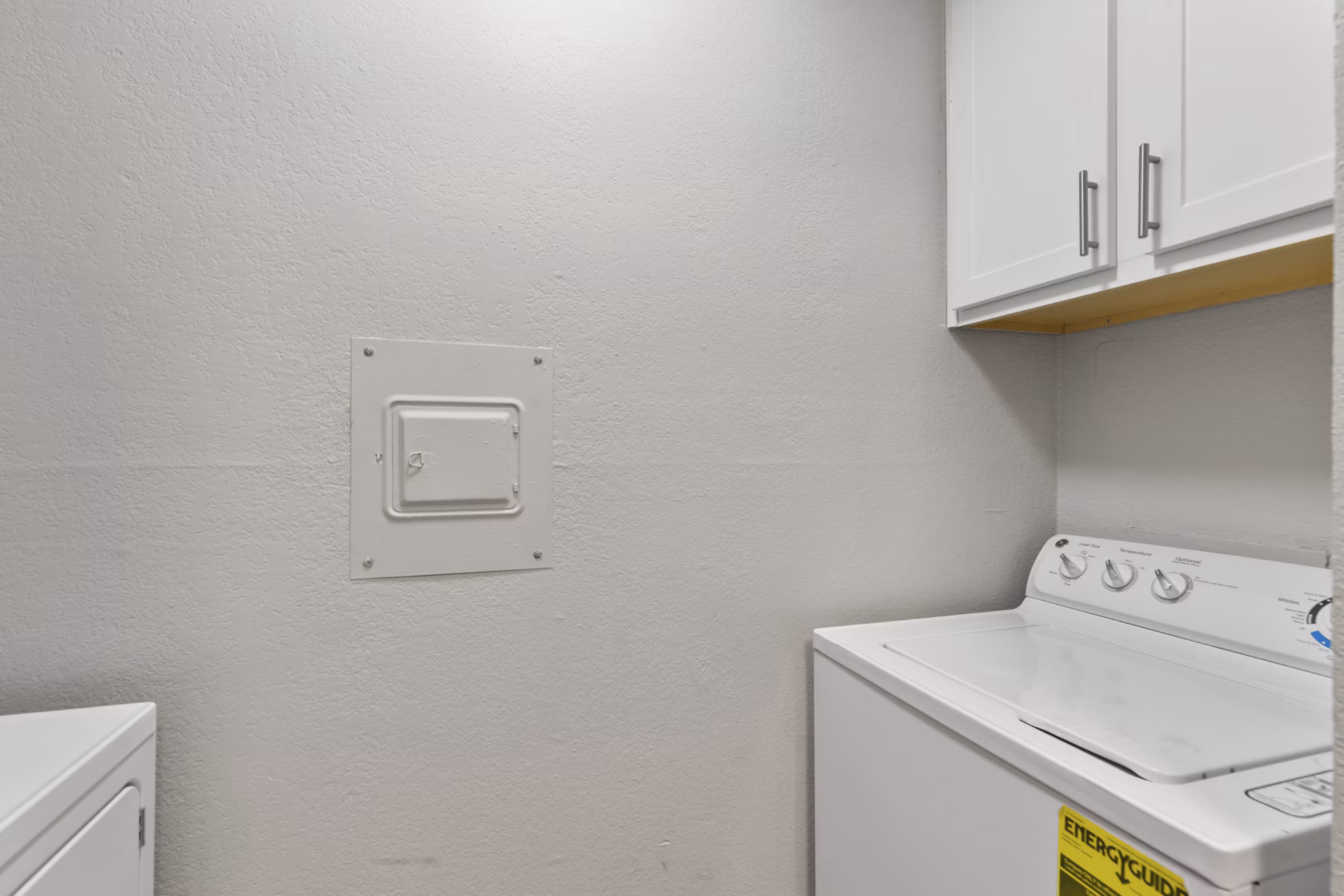 Laundry room with modern appliances in Creekwood Apartments offering convenience and style for residents