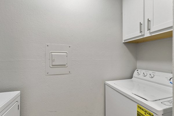 Laundry room with modern appliances in Creekwood Apartments offering convenience and style for residents