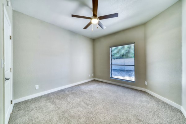 Bedroom with modern decor and large windows at Hayden Park Apartments, a Greystar luxury apartment community