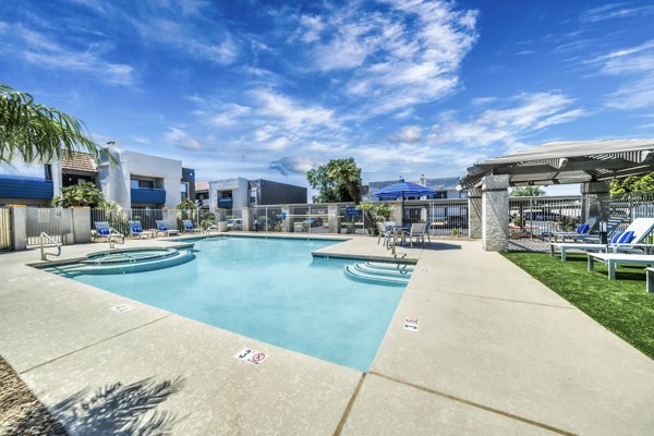 Spacious outdoor pool area surrounded by lush greenery at Hayden Park Apartments