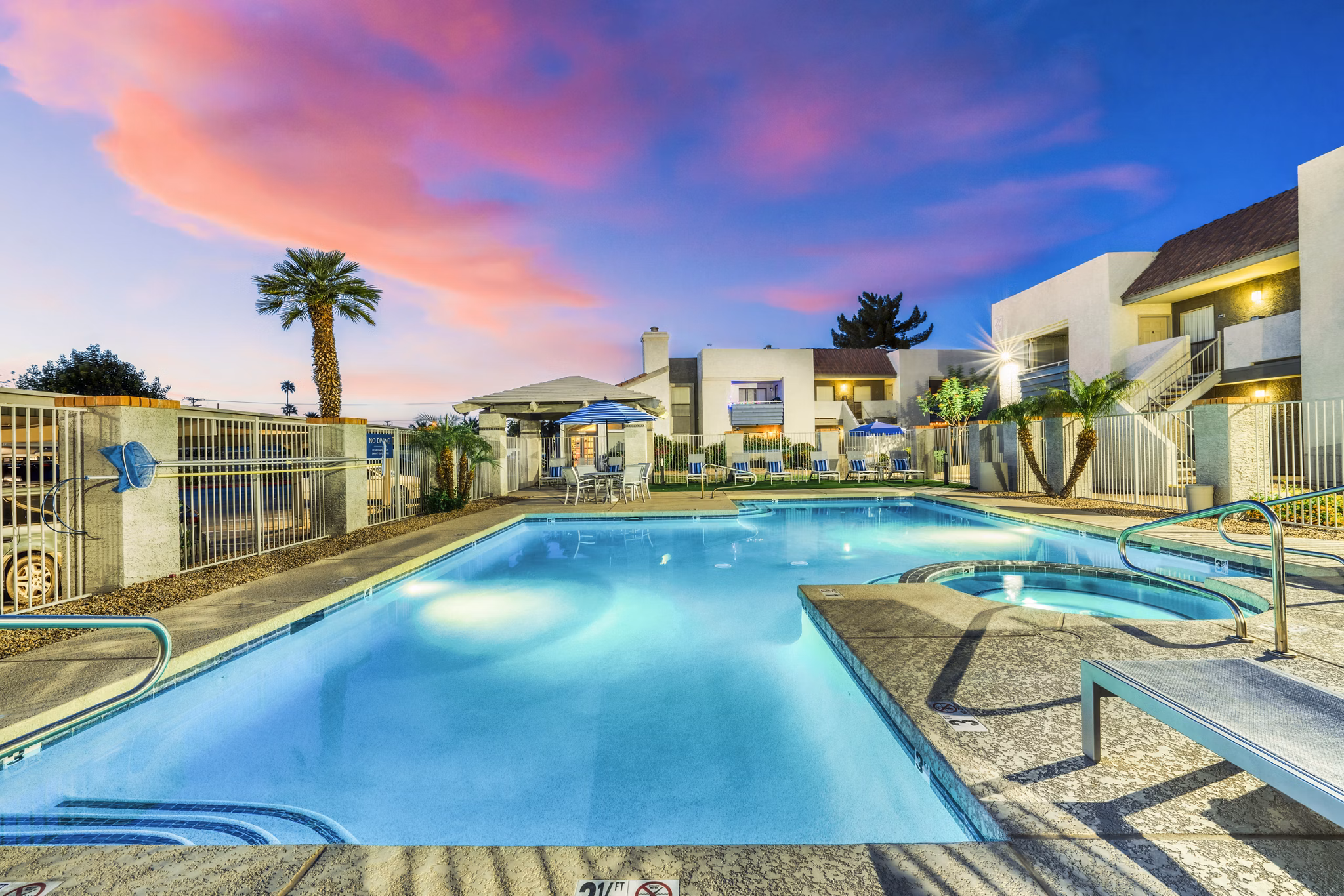 Resort-style pool at Hayden Park Apartments with surrounding lounge chairs and lush landscaping