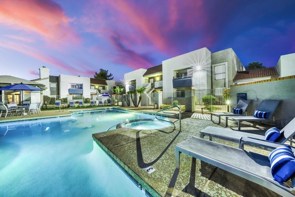 Relaxing outdoor pool with lounge chairs at Hayden Park Apartments, offering a luxury lifestyle experience in a serene setting