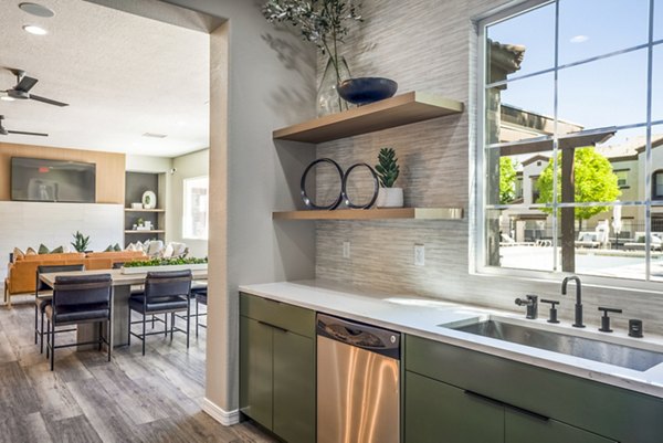 Clubhouse kitchen with modern appliances and seating at Cantata at the Trails Apartments, a luxury community by Greystar