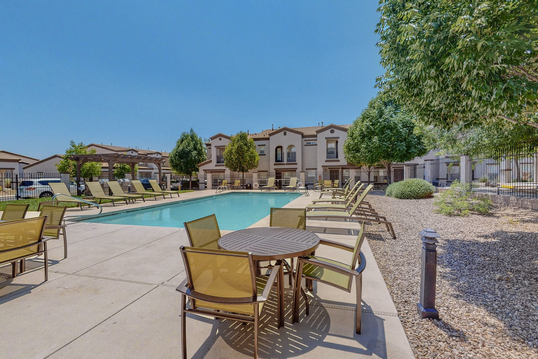 Resort-style pool with lush landscaping at Cantata at the Trails Apartments