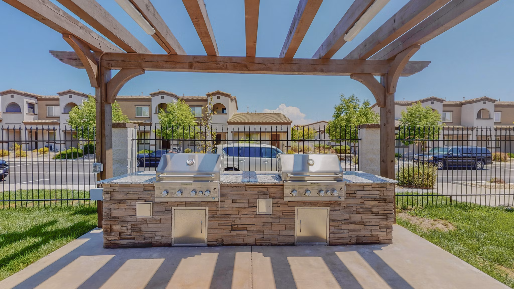 Modern grill area with seating at Cantata at the Trails Apartments, ideal for outdoor dining experiences