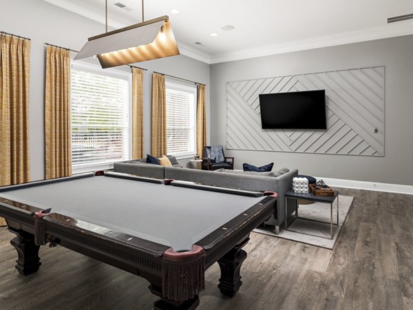 Clubhouse game room with pool table and large-screen TV at Mandalay Villas Apartments
