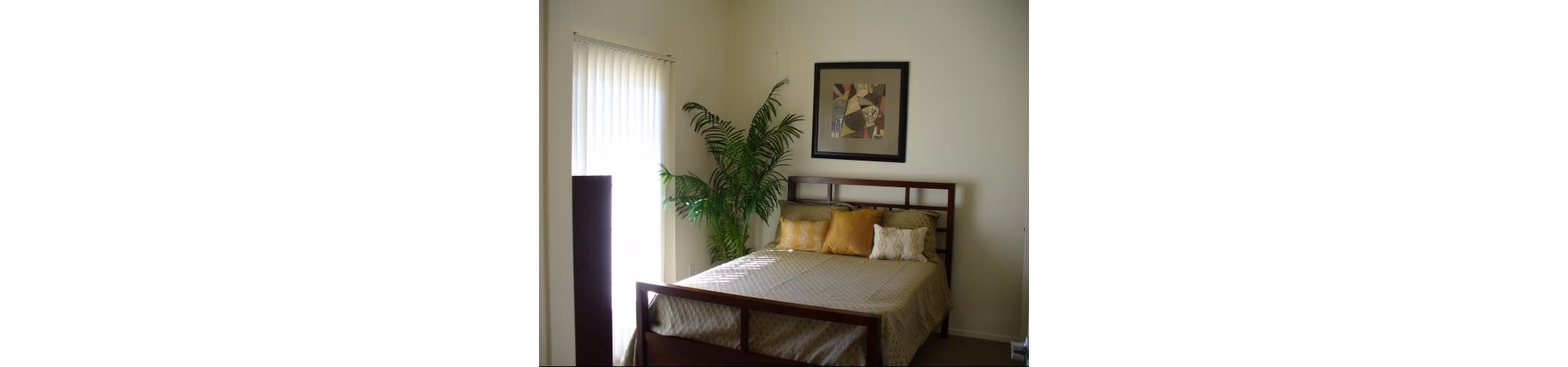 Bedroom featuring modern design and large windows at Raincross Senior Village Apartments