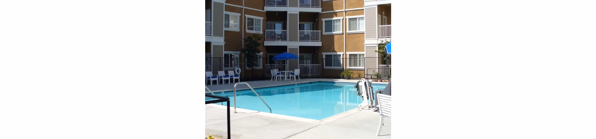 Resort-style pool at Raincross Senior Village Apartments with surrounding lounge chairs