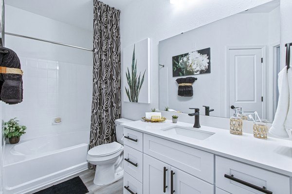 Luxury bathroom featuring marble countertops and modern fixtures at 1000 West Apartments