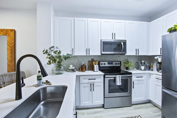 Modern kitchen with stainless steel appliances in 1000 West Apartments