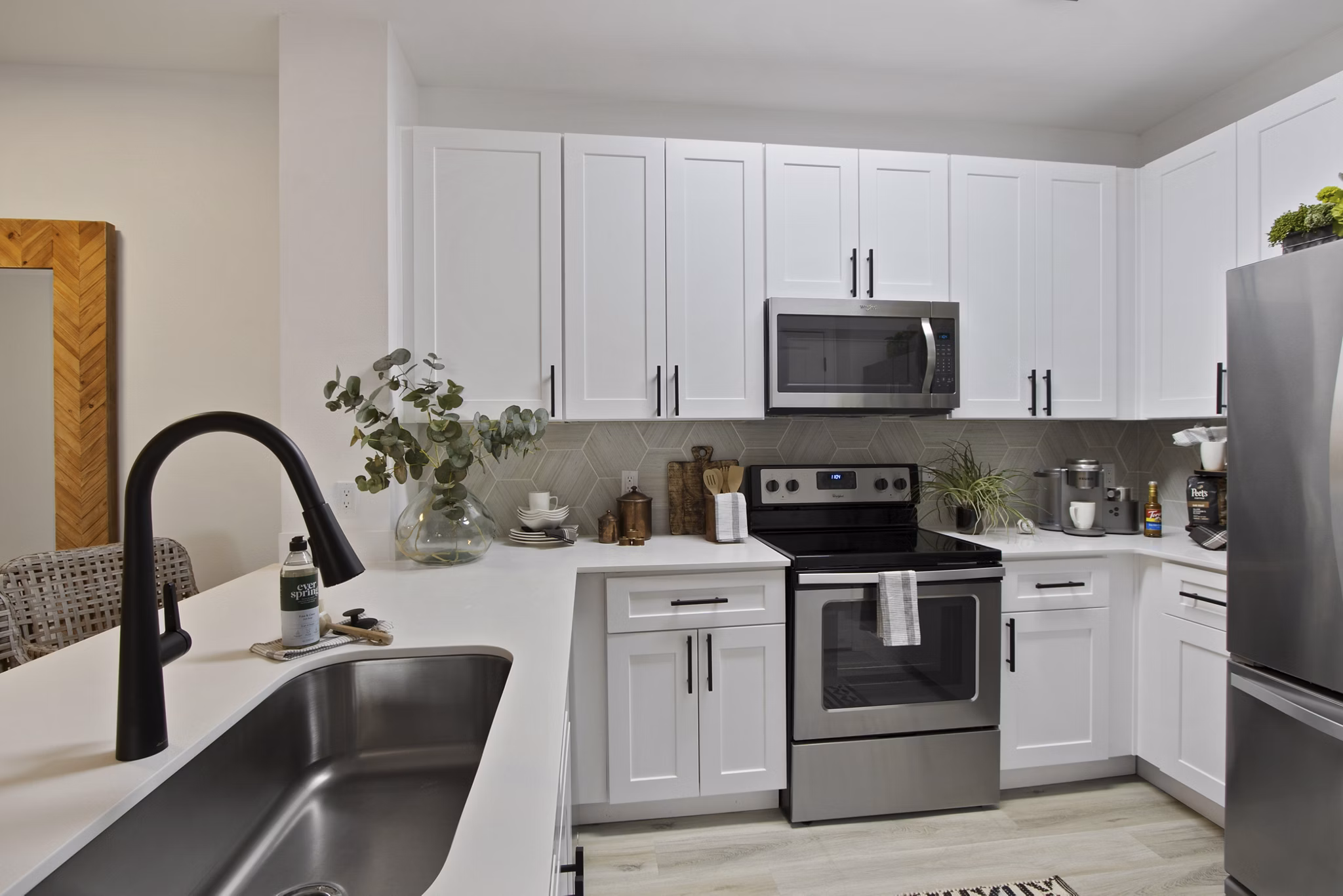 Modern kitchen with stainless steel appliances at 1000 West Apartments, offering luxury living in a prime urban location