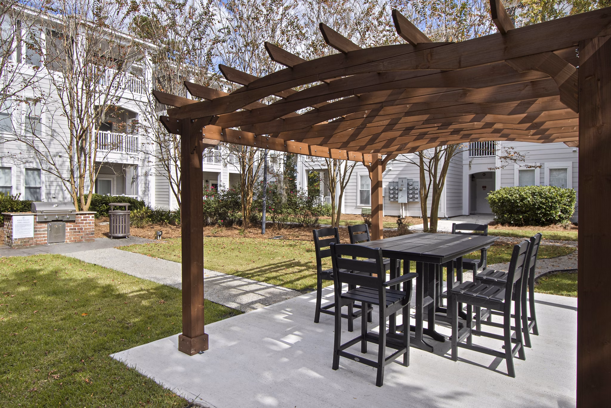 Outdoor grill area with cozy patio seating at 1000 West Apartments, ideal for gatherings and relaxation