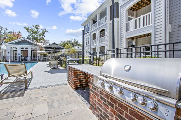 Outdoor grill area with cozy patio seating at 1000 West Apartments, ideal for gatherings and relaxation