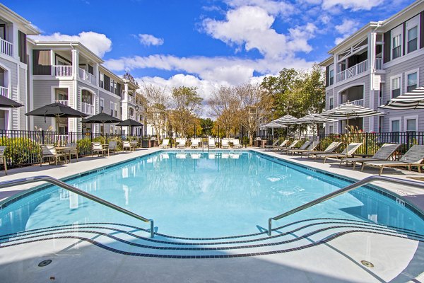 Luxurious pool at 1000 West Apartments with lounge chairs and greenery