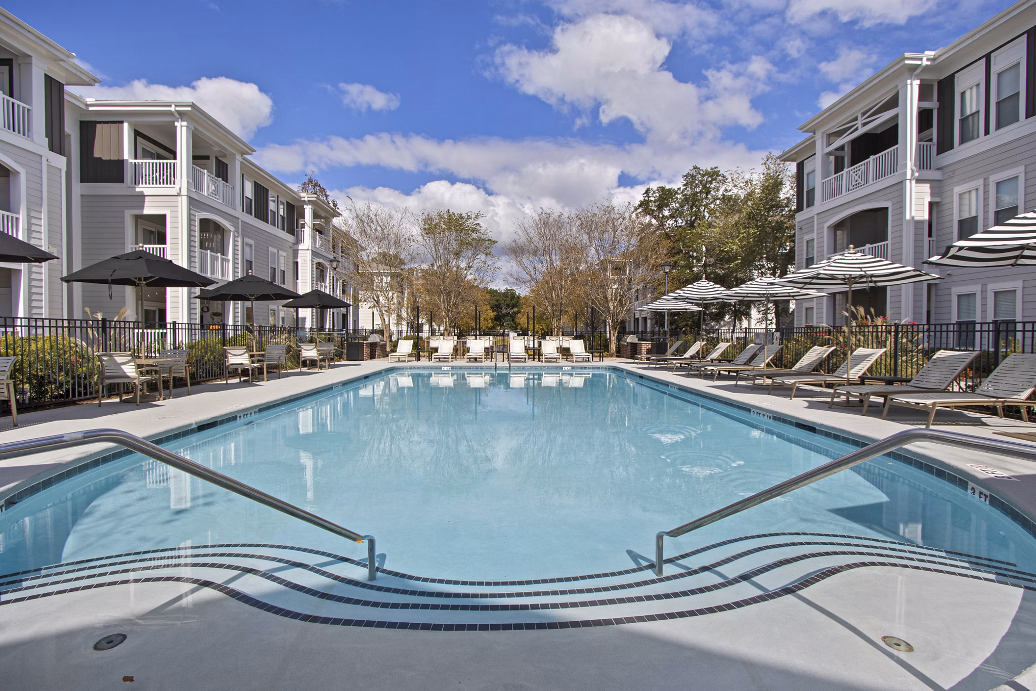 Luxurious outdoor pool surrounded by lush landscaping at 1000 West Apartments
