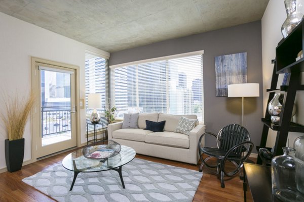 Spacious living room featuring modern decor and large windows at Solera Apartments, luxury residences by Greystar