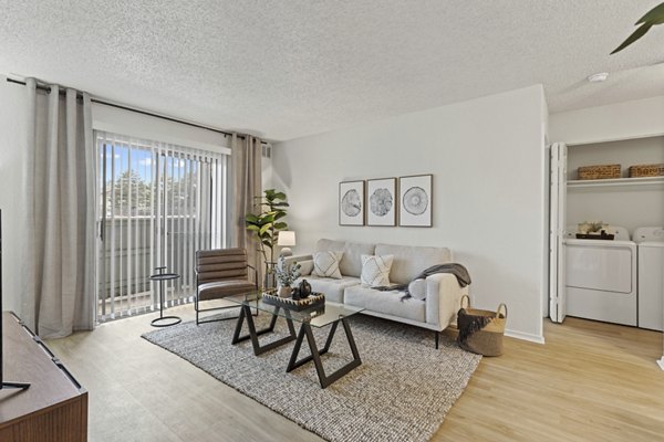Spacious living room with modern decor in Coventry Park Apartments, featuring elegant furniture and natural lighting for a luxurious lifestyle