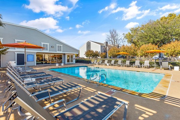 Outdoor pool surrounded by sun loungers at Coventry Park Apartments offering a luxurious and relaxing atmosphere for residents