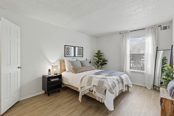 Cozy bedroom with modern furnishings at Cascades at Southern Hills Apartments