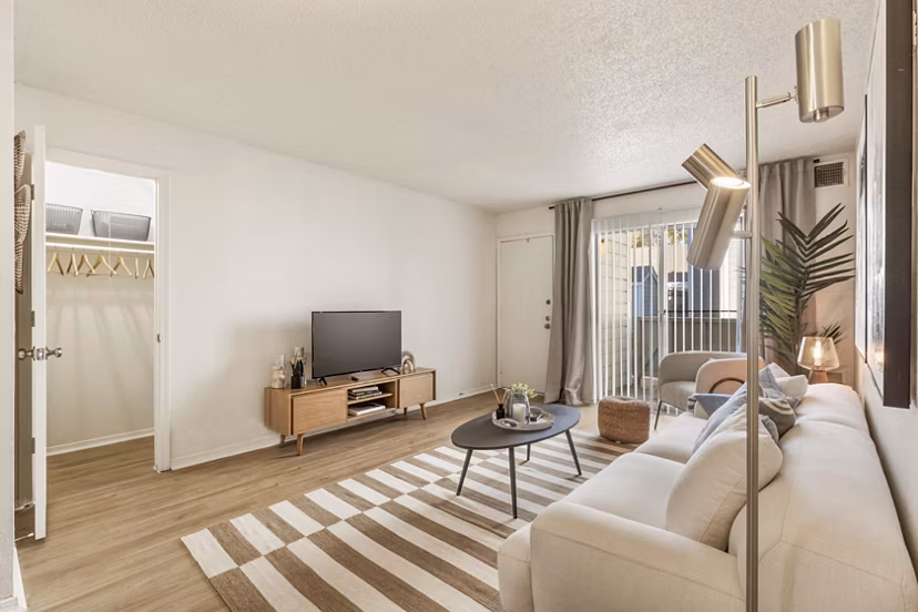 Spacious living room with modern decor and natural lighting in Cascades at Southern Hills Apartments