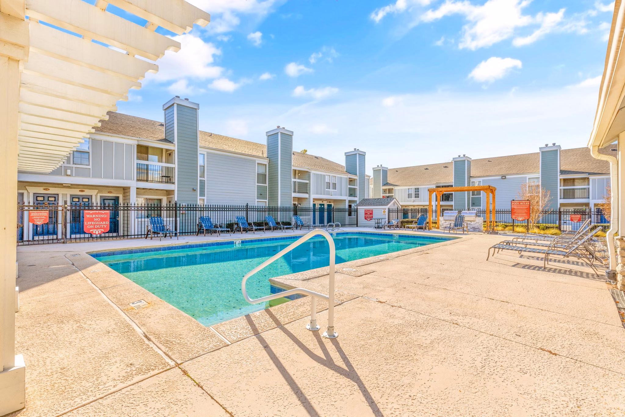 Resort-style pool with palm trees at Cascades at Southern Hills Apartments