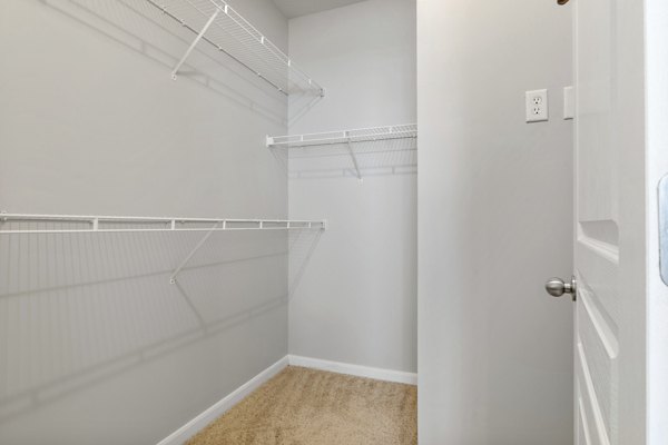 Walk-in closet with ample shelving and storage space in Oberlin Court Apartments, ideal for organizing luxury living items