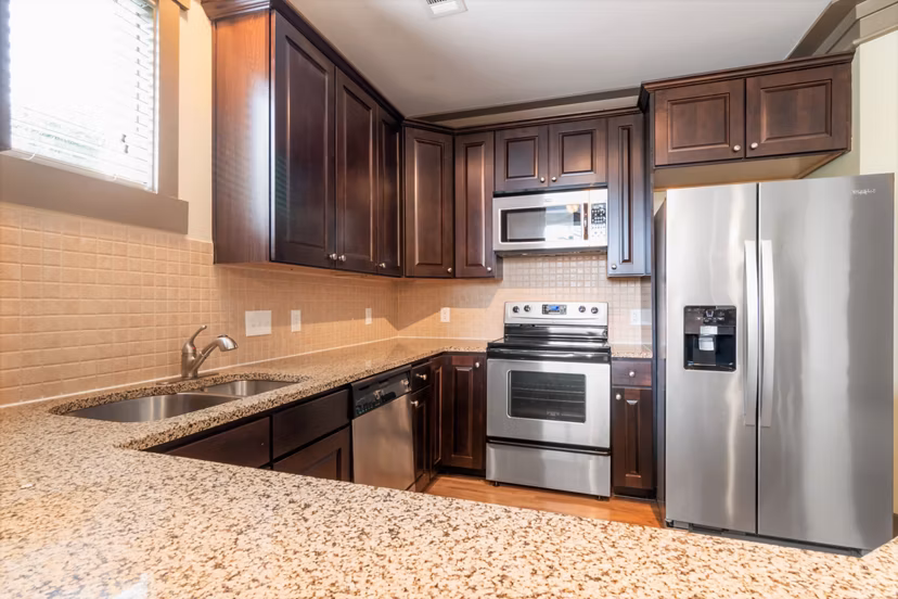 Modern kitchen with stainless steel appliances at Oberlin Court Apartments, featuring sleek countertops and ample cabinet space