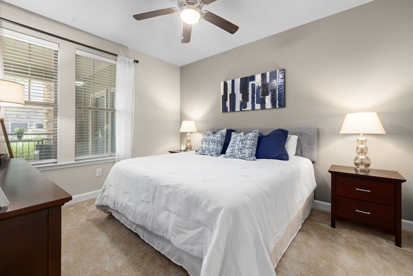 Bedroom featuring modern decor and large windows in Artisan at Brightleaf Apartments