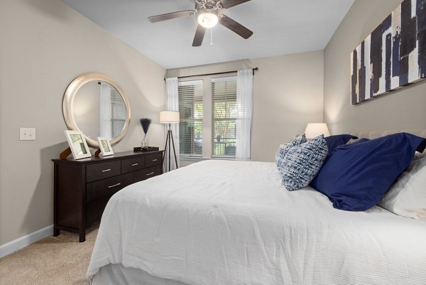 Bedroom with stylish furnishings and large windows at Artisan at Brightleaf Apartments