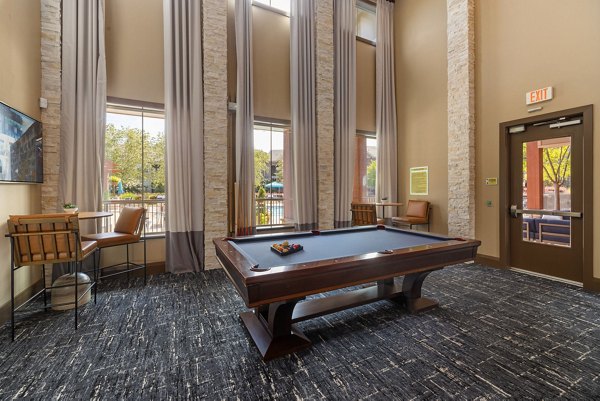 Game room with billiards and lounge seating at Artisan at Brightleaf Apartments