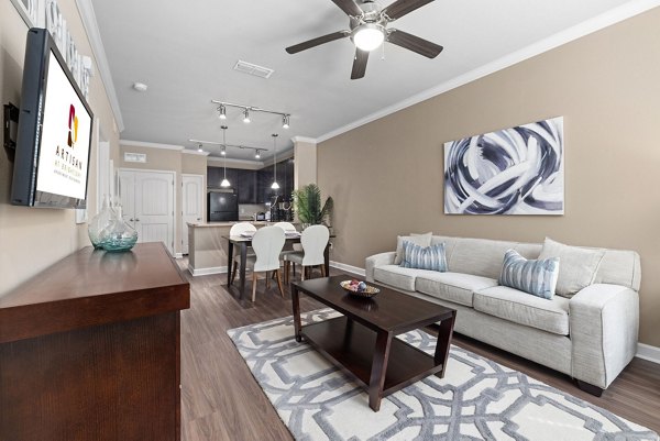 Contemporary living room with stylish decor and large windows at Artisan at Brightleaf Apartments