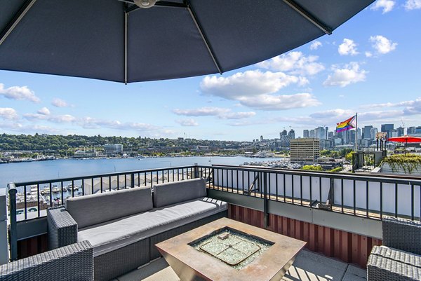 Cozy fire pit seating area at 1611 on Lake Union Apartments, offering inviting outdoor relaxation with waterfront views