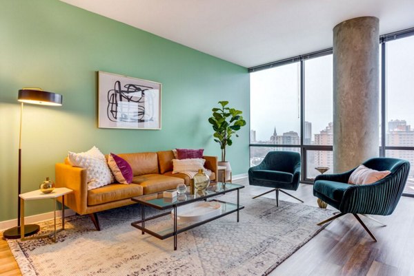 Spacious living room with modern decor and large windows at SoNo East Apartments, luxury living in vibrant urban setting