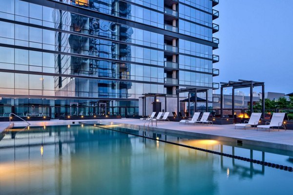 Relaxing pool area at SoNo East Apartments with modern seating and lush greenery