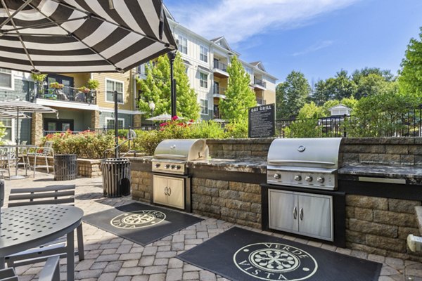 Outdoor grill area at Verde Vista Apartments with modern seating and lush landscaping