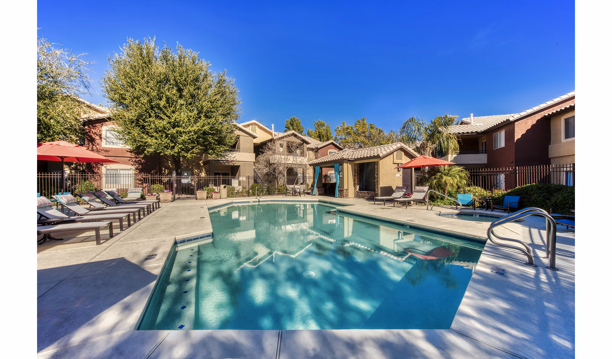 Poolside retreat with lounge chairs and palm trees at Allure at Tempe Apartments