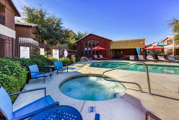 Resort-style pool area with lounge chairs at Allure at Tempe Apartments