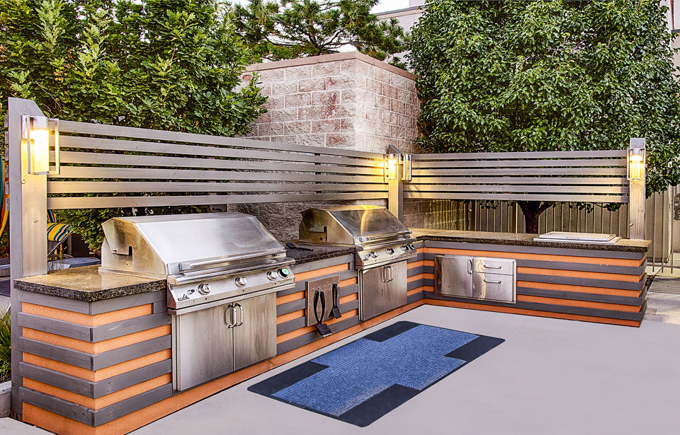 Spacious outdoor grill area with modern seating at Arista Uptown Apartments, perfect for social gatherings and alfresco dining