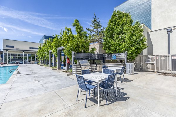 Pool and patio area with grill at Arista Uptown Apartments