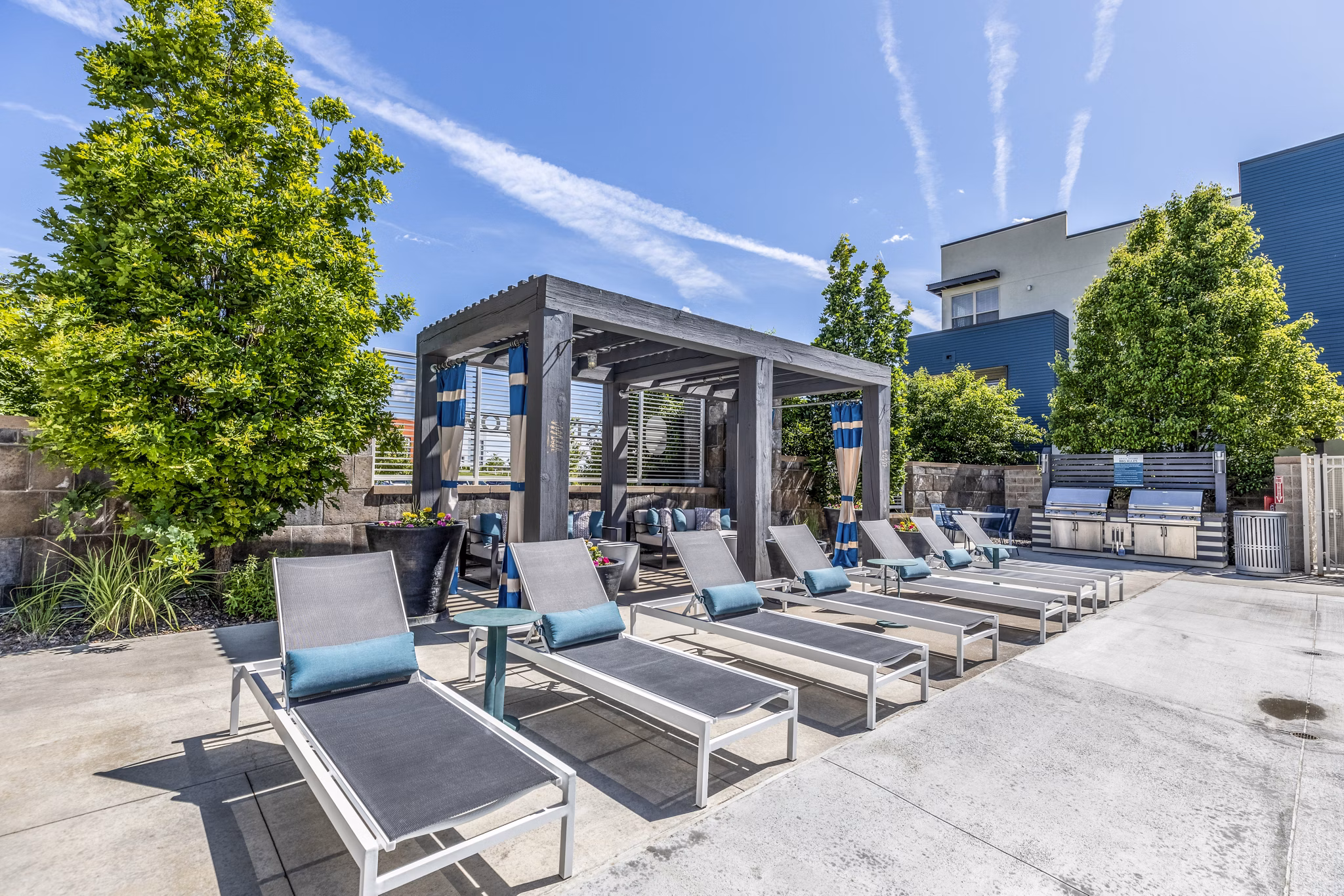 Outdoor pool and patio with BBQ grill area at Arista Uptown Apartments, offering luxury amenities for residents