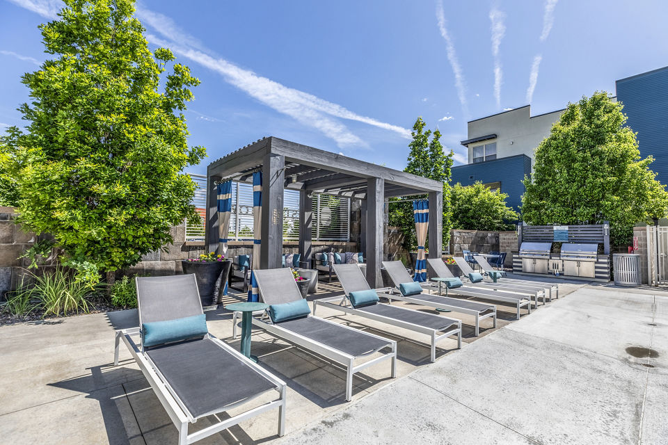 Outdoor pool and patio with BBQ grill area at Arista Uptown Apartments, offering luxury amenities for residents