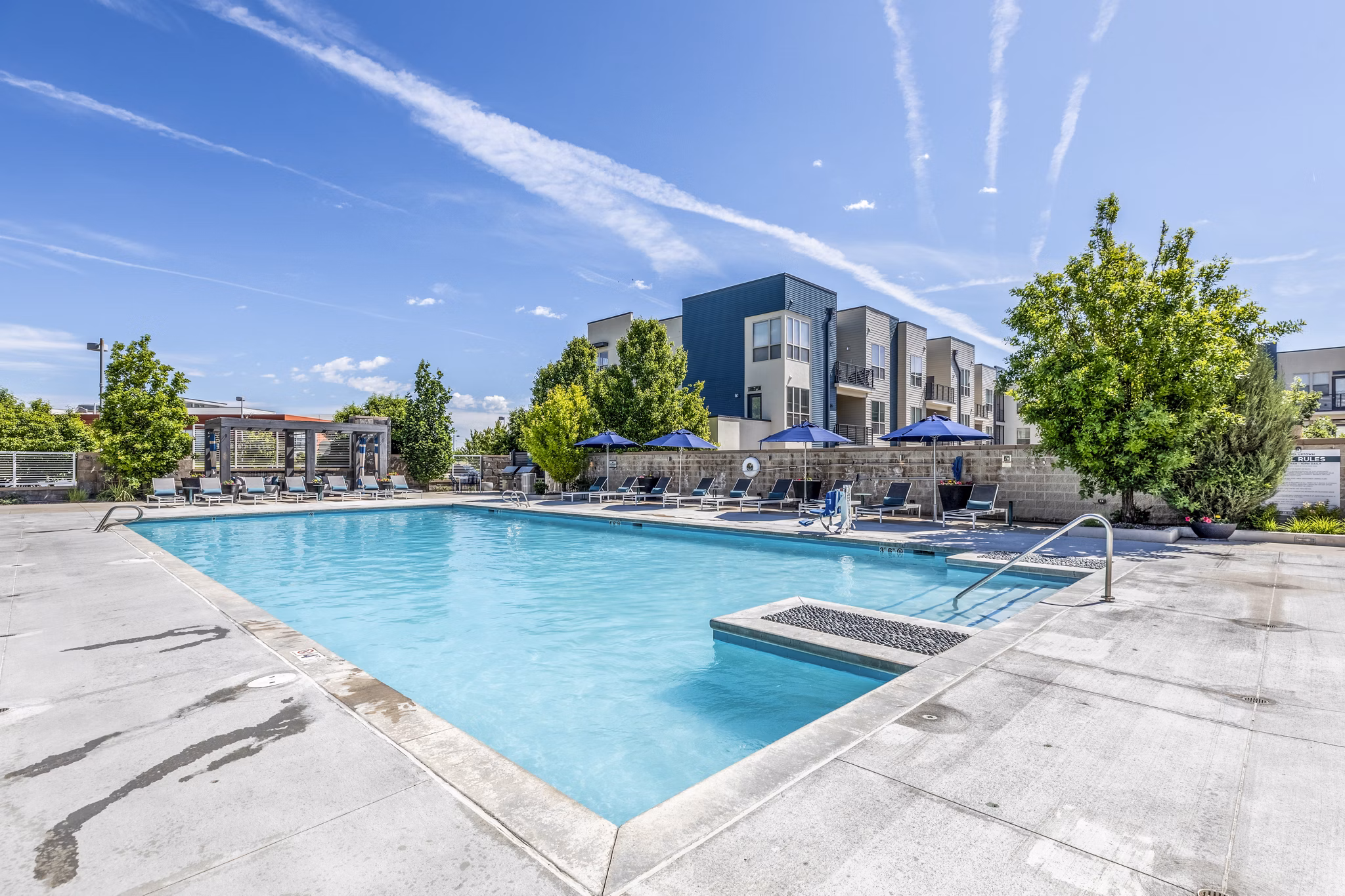 Luxurious poolside lounging area at Arista Uptown Apartments with modern amenities