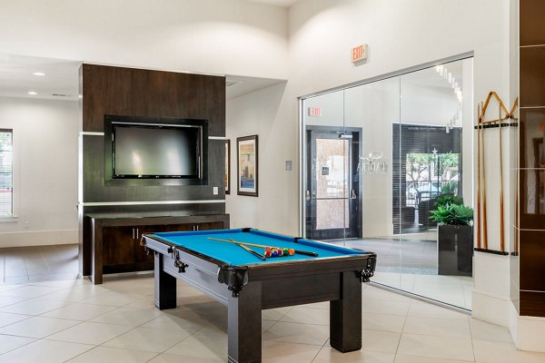 Game room featuring pool tables and modern seating at Ladera Apartments