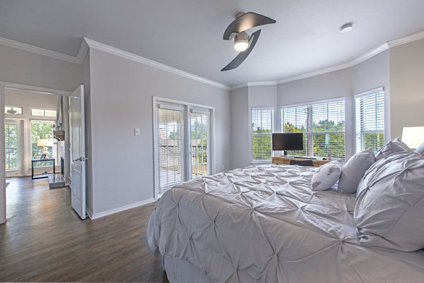 Cozy bedroom with modern decor and large windows at Barton Creek Villas Apartments