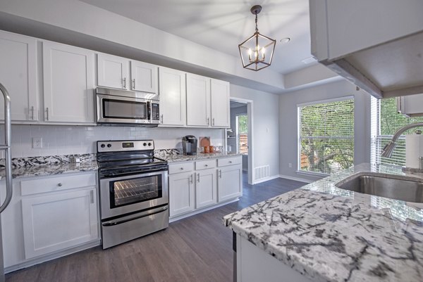 Modern kitchen with granite countertops and stainless steel appliances at Barton Creek Villas Apartments