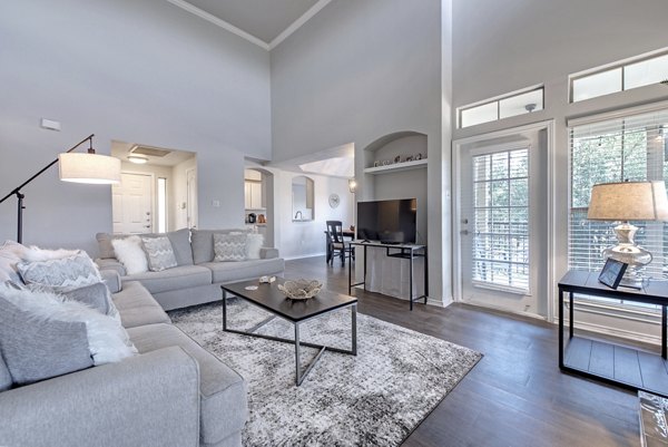 Elegant living room with plush seating and large windows at Barton Creek Villas Apartments, providing luxury and comfort in serene surroundings