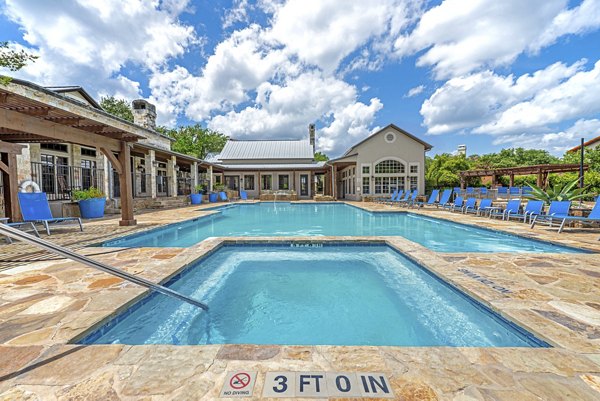 Outdoor pool area with lounge chairs at Barton Creek Villas Apartments offering luxury living