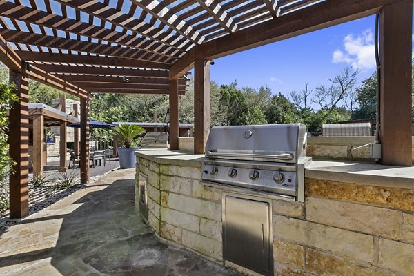 Outdoor grilling area with modern furniture at Barton Creek Villas Apartments
