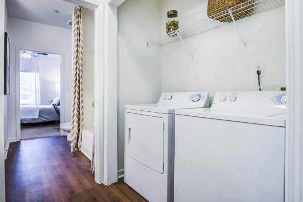 Modern laundry room with high-efficiency machines at The Vinoy at Innovation Park Apartments, providing convenience and luxury living